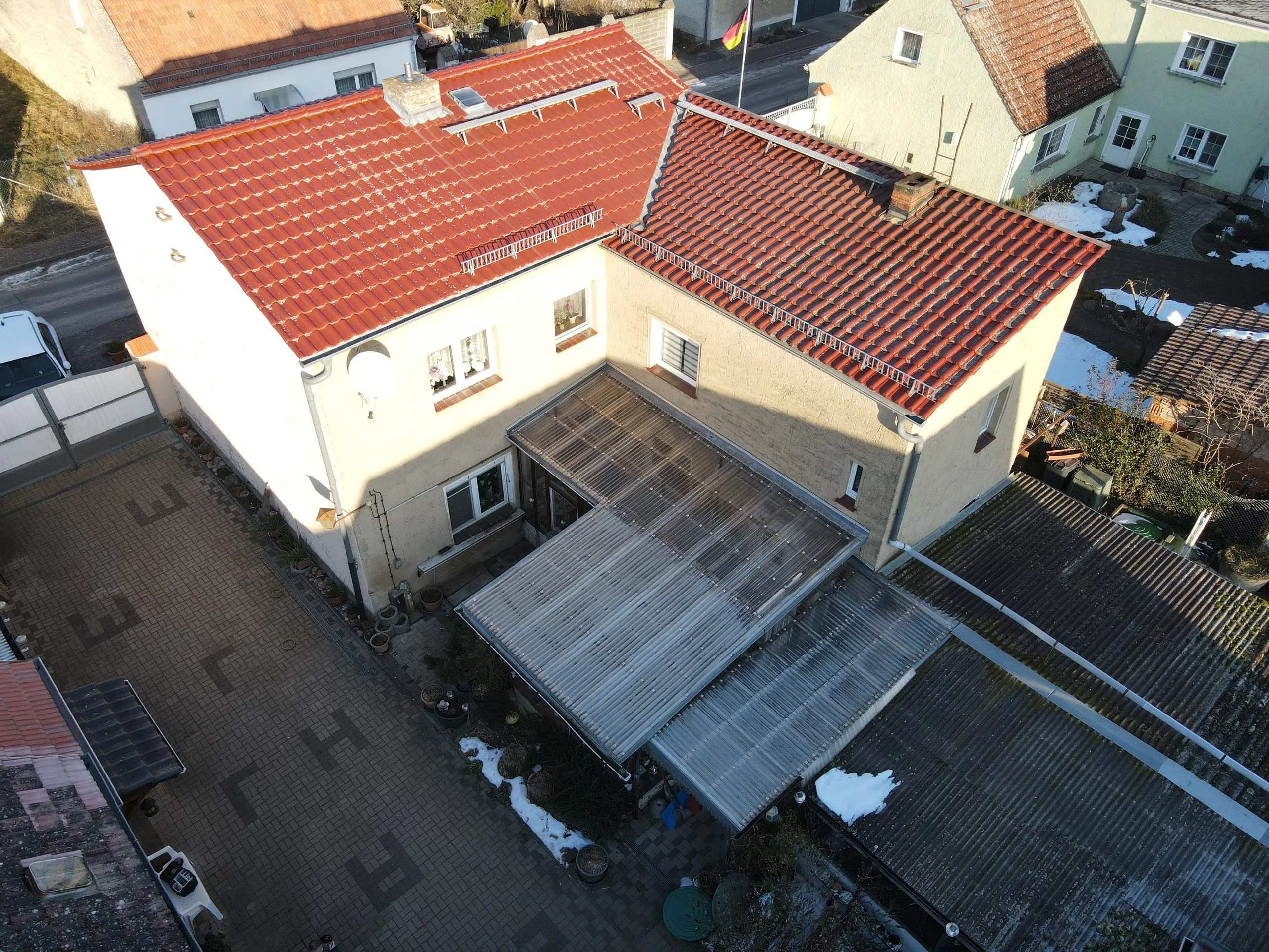 Wohnhaus mit rotem Ziegeldach und Wintergarten aus der Luft — Ausgangslage vor der PV-Installation
