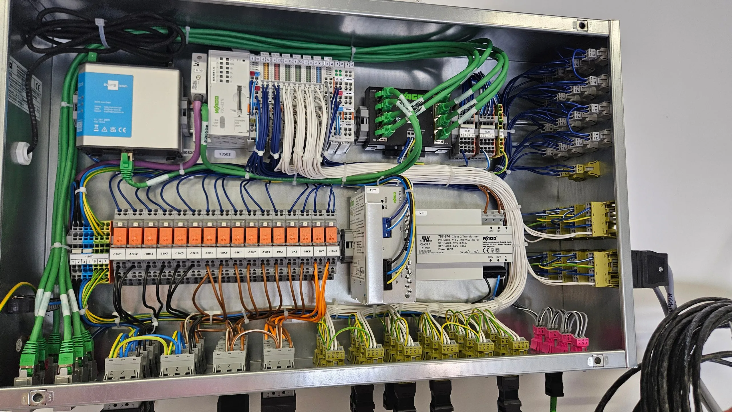 Geöffneter Schaltschrank mit sauber gekämmter Verdrahtung, Reihenklemmen und WAGO-Steuerungsmodulen