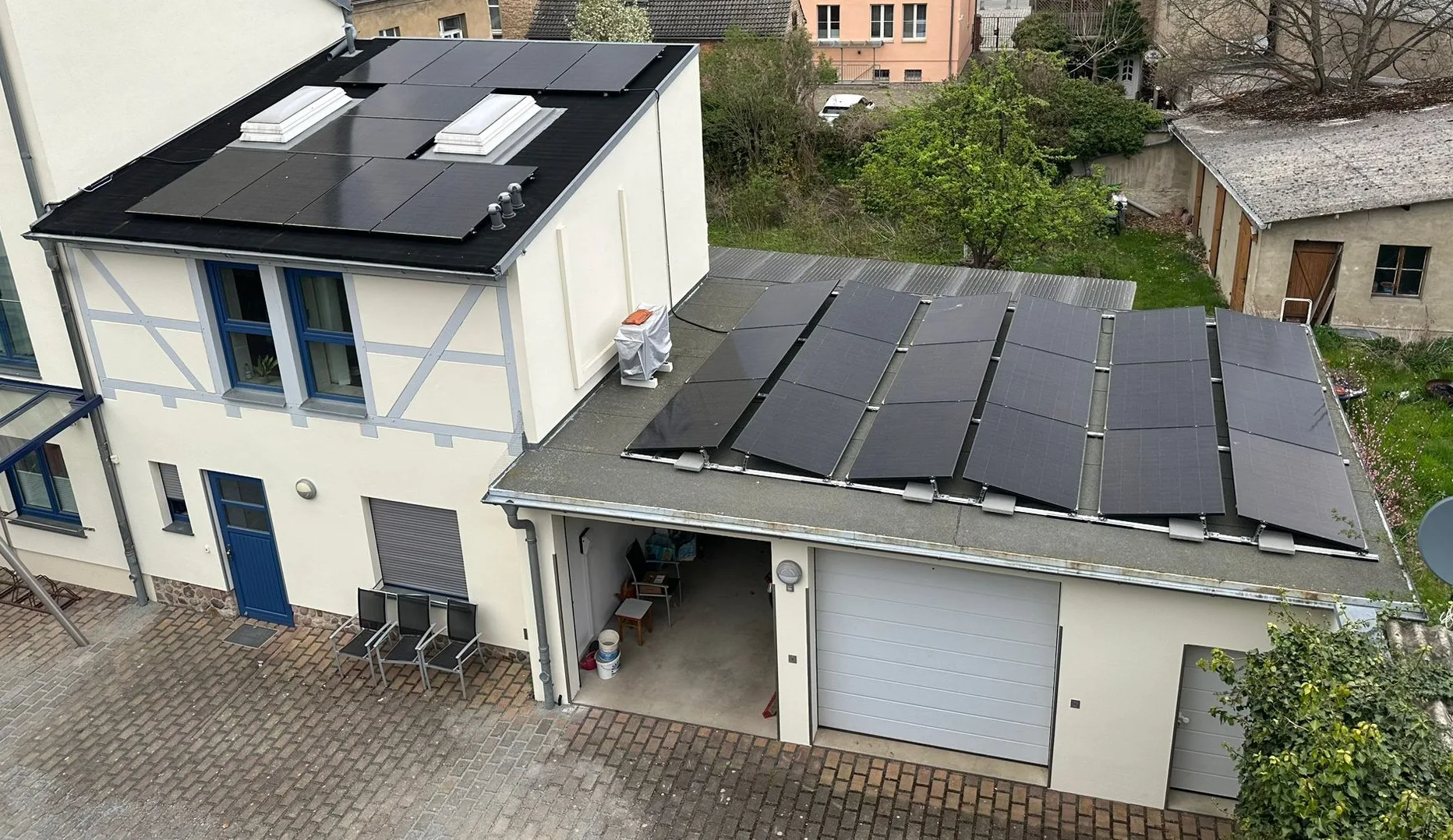 Luftaufnahme einer Apotheke in Treuenbrietzen mit schwarzen Photovoltaikmodulen auf Haupt- und Nebendach