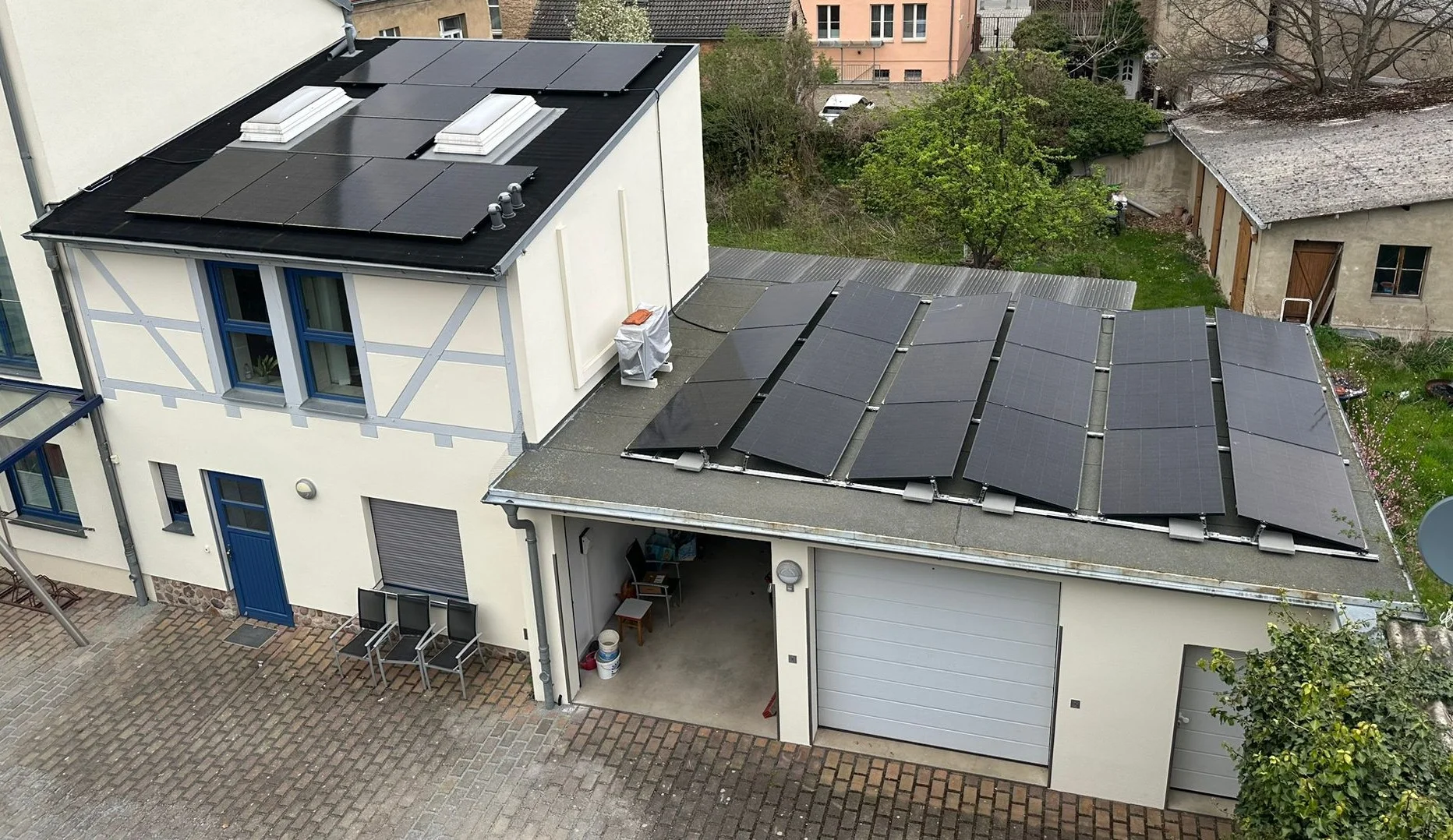 Luftaufnahme einer Apotheke in Treuenbrietzen mit schwarzen Photovoltaikmodulen auf Haupt- und Nebendach