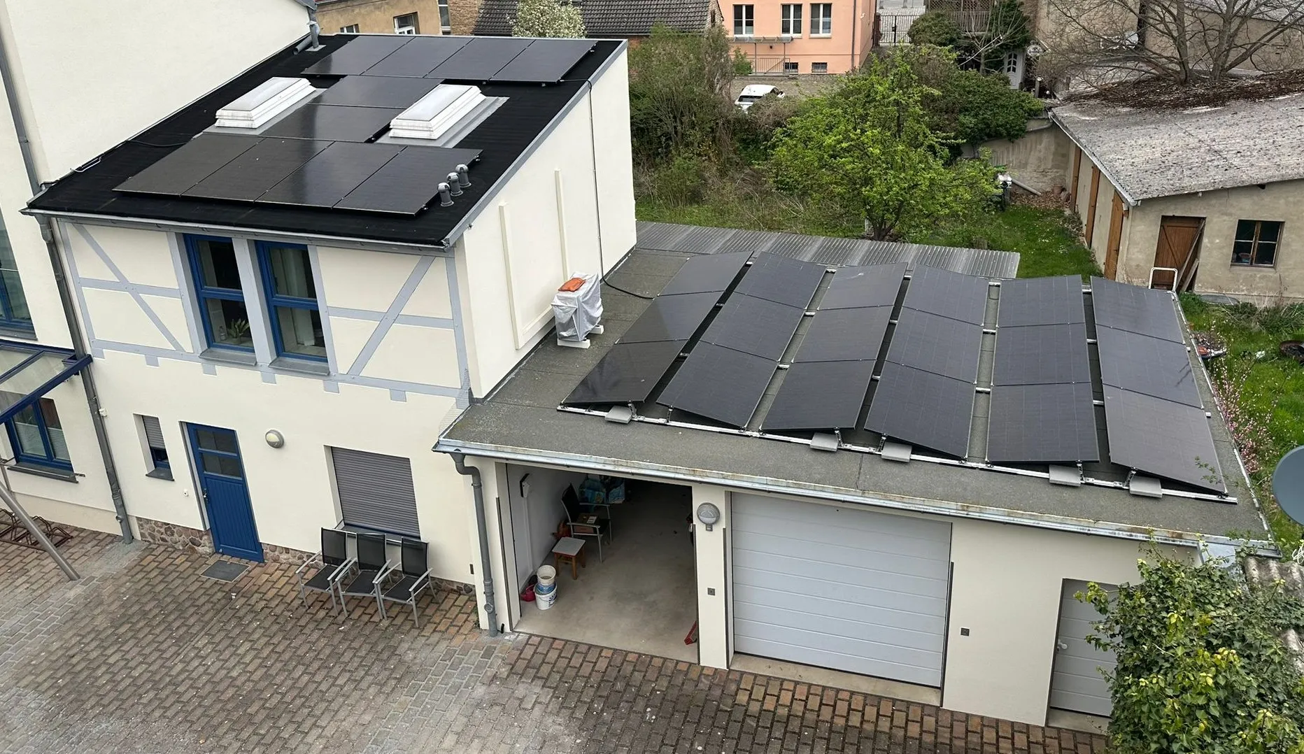 Luftaufnahme einer Apotheke in Treuenbrietzen mit schwarzen Photovoltaikmodulen auf Haupt- und Nebendach
